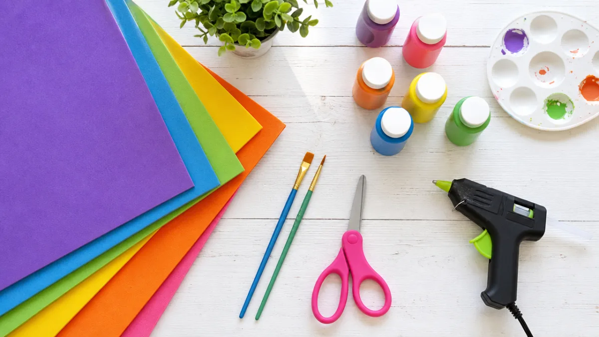 a flat lay of craft foam sheets, paint, scissors, and hot glue…