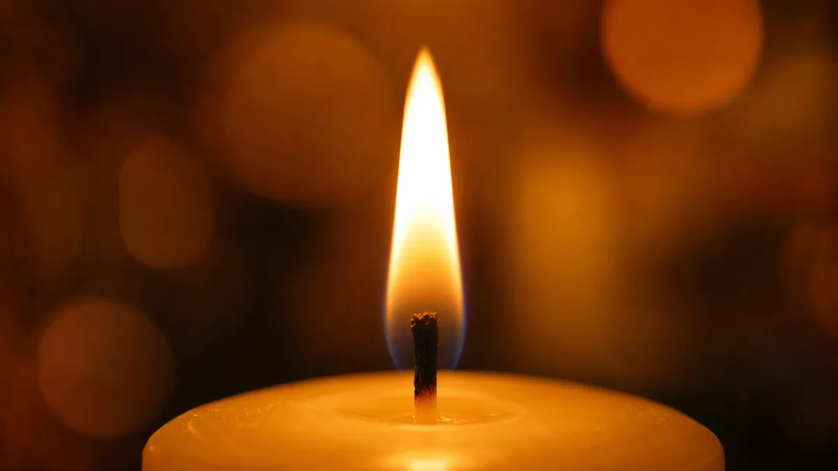 close-up of a candle flame burning cleanly above a trimmed wick, soft…