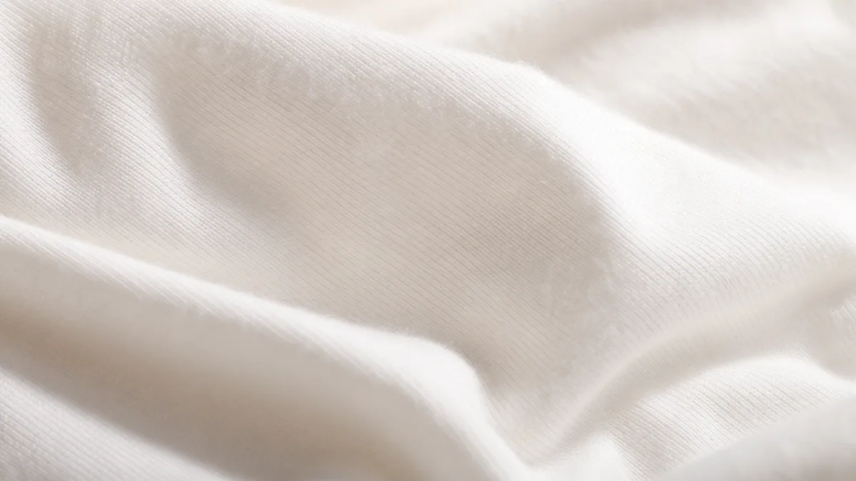 a close-up of soft white cotton fabric texture under warm studio lighting…