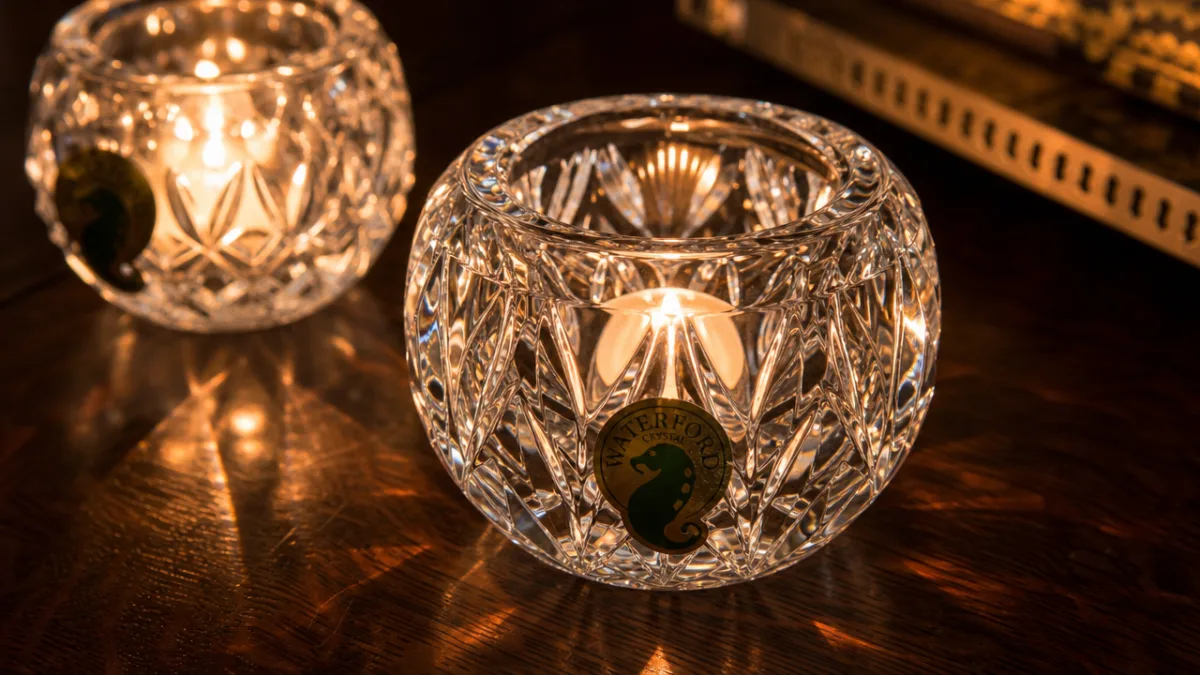 a close-up of Waterford crystal candle holders on a dark walnut table,…