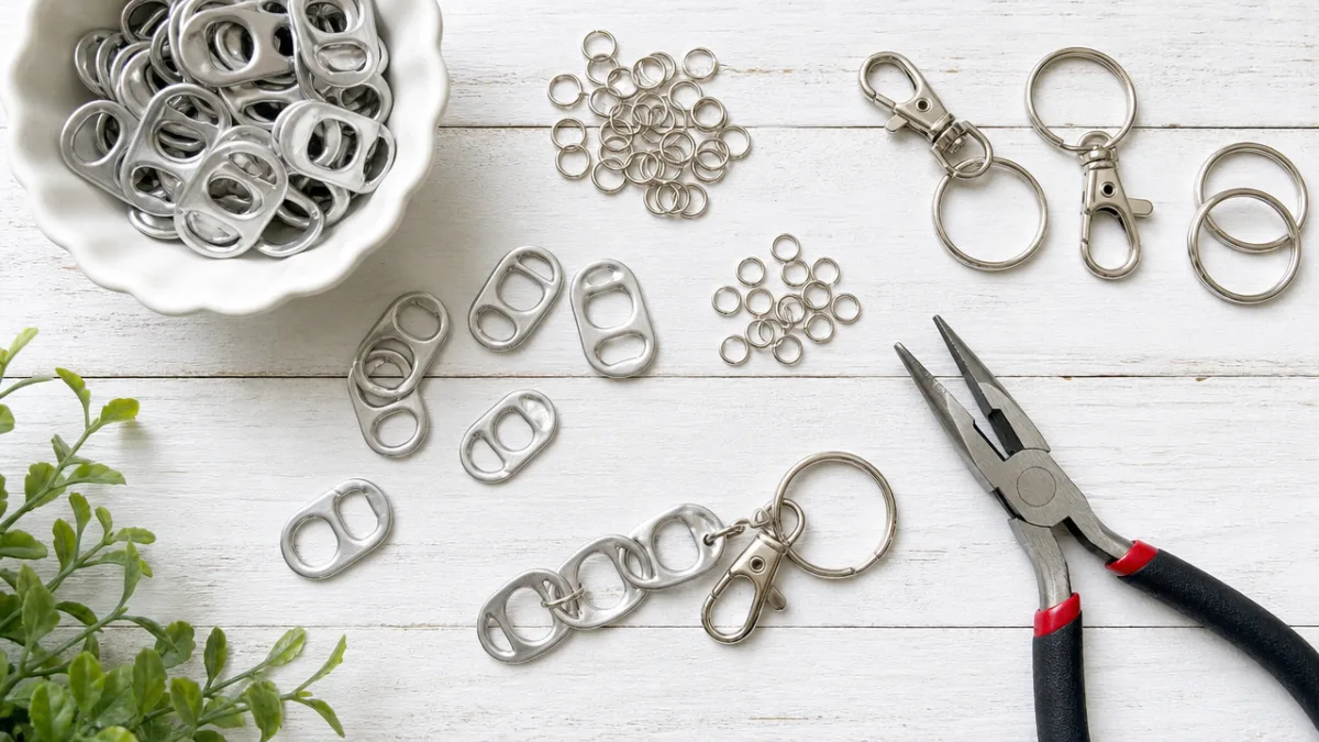 a flat lay of soda tabs, pliers, jump rings and keychain hardware…