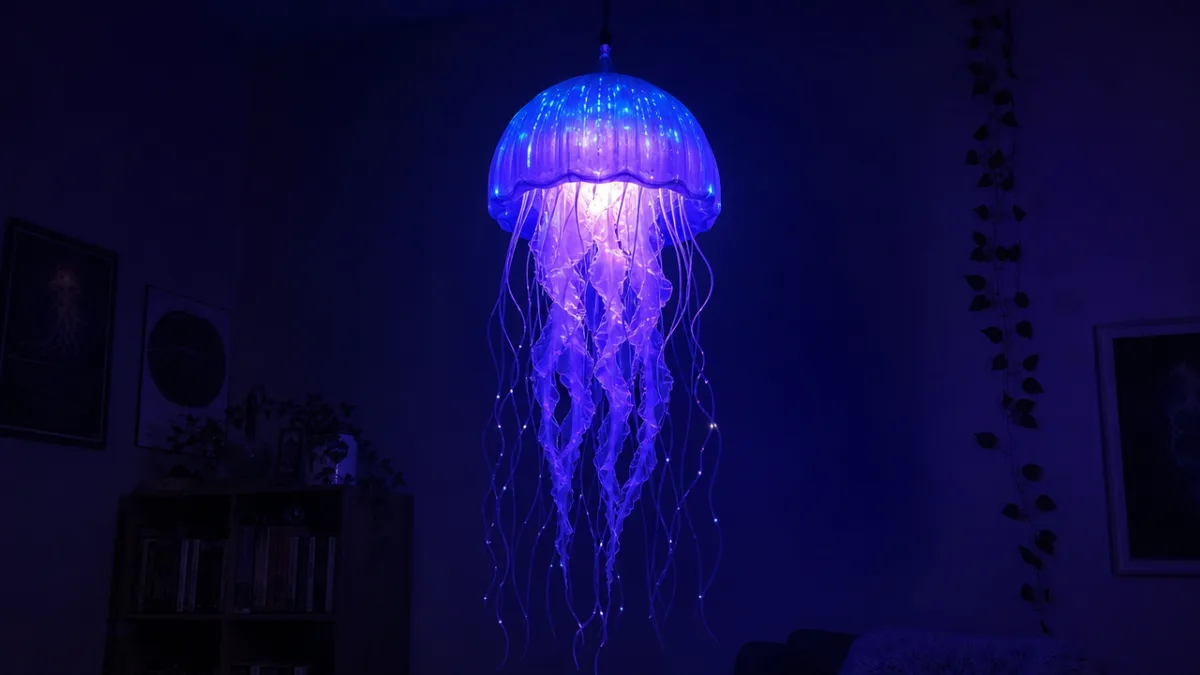 a glowing jellyfish lamp suspended in a dark room, deep blue and…