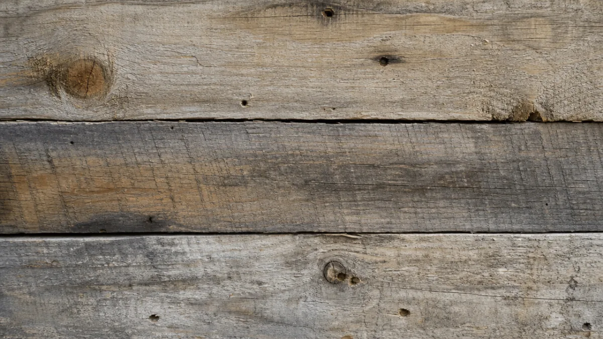 close-up of weathered reclaimed pallet wood boards with natural grain textures, soft…